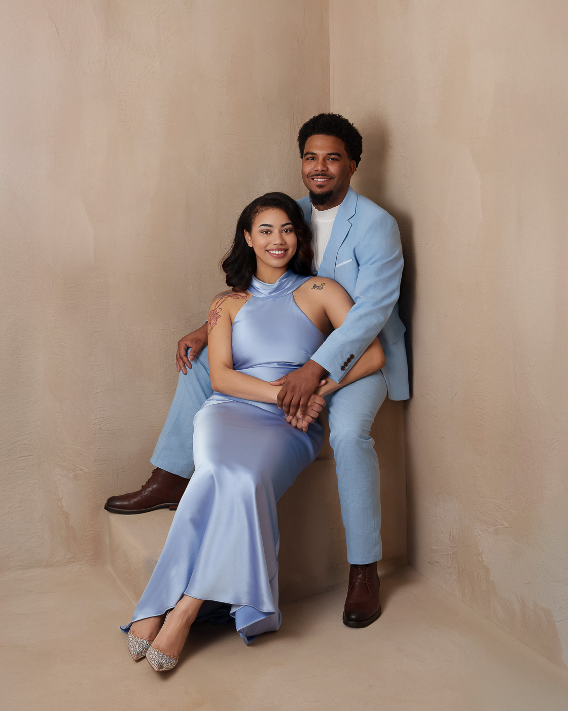 Elegant couple session in San Antonio with beige background and blue elegant outfits